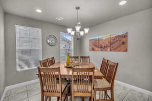 Tiled dining room featuring a notable chandelier