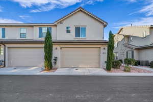 View of front of home with central AC unit and a garage