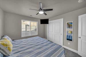 Carpeted bedroom with a closet and ceiling fan