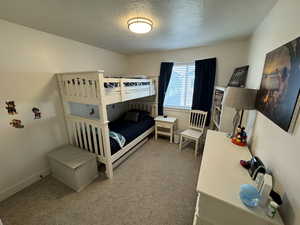 Carpeted bedroom with a textured ceiling