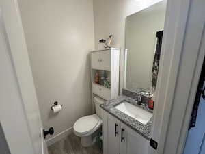 Bathroom with vanity, toilet, and hardwood / wood-style floors