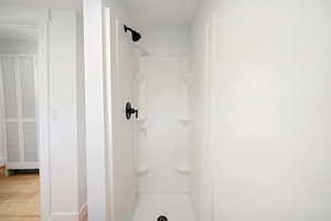 Bathroom with a shower and wood-type flooring