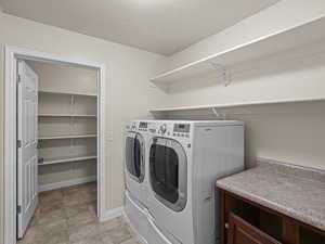 Laundry area featuring a textured ceiling and washing machine and clothes dryer