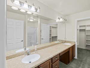 Bathroom featuring toilet, a shower with door, and vanity