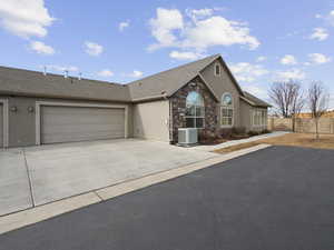 Ranch-style home featuring central AC unit and a garage