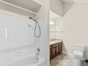 Full bathroom featuring tub / shower combination, toilet, tile patterned flooring, and vanity