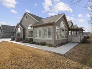 View of side of property featuring a lawn and central air condition unit