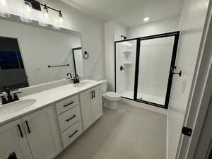 Bathroom featuring vanity, toilet, walk in shower, and tile patterned flooring