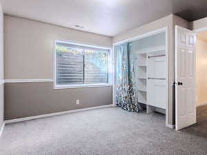 Unfurnished bedroom with carpet flooring and a textured ceiling