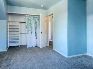 Unfurnished bedroom with a closet and carpet