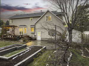 Back house at dusk featuring french doors and a deck