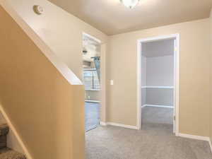 Hall with light carpet and a textured ceiling