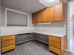 Unfurnished office featuring carpet flooring and built in desk