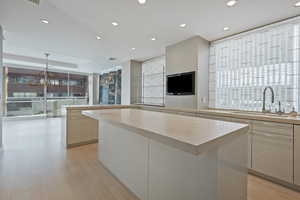 Kitchen with sink, white cabinetry, and a kitchen island