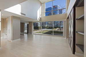 Interior space featuring a towering ceiling and light hardwood / wood-style floors