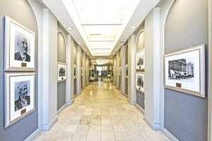 Corridor featuring a raised ceiling and light tile patterned floors