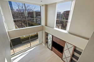 Living room with light hardwood / wood-style floors, expansive windows, and a fireplace