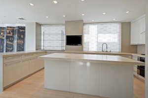 Kitchen featuring light hardwood / wood-style floors, sink, kitchen peninsula, and a kitchen island