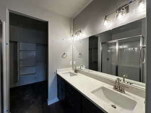 Bathroom with a shower with shower door and vanity