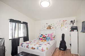 Bedroom featuring vaulted ceiling and hardwood / wood-style floors