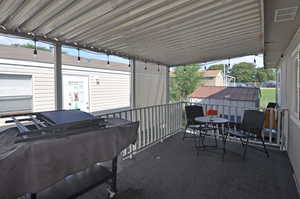 View of patio featuring a shed and grilling area