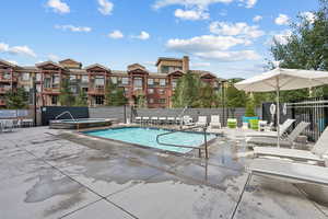 View of swimming pool with a community hot tub and a patio