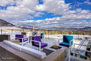 Snow covered patio with a mountain view and an outdoor living space with a fire pit