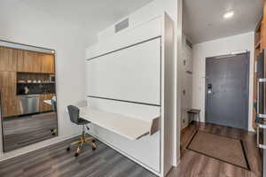 Home office with sink and dark hardwood / wood-style floors