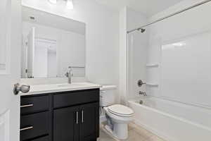 Full bathroom featuring shower / washtub combination, toilet, tile patterned floors, and vanity