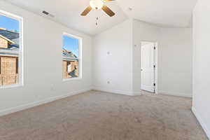 Empty room featuring plenty of natural light, light colored carpet, lofted ceiling, and ceiling fan