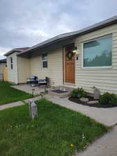 View of front of home with a front yard and a patio area