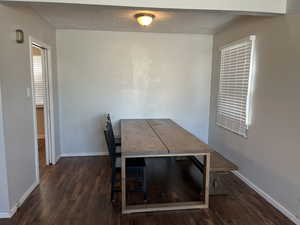 Unfurnished dining area with dark wood-type flooring