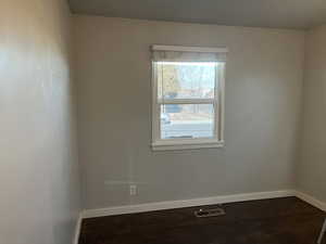 Spare room featuring dark wood-type flooring