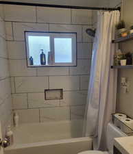 Full bathroom with shower / bath combo, toilet, and vanity