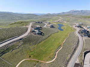 Aerial view of property and surrounding area with a water and mountain view and a golf club