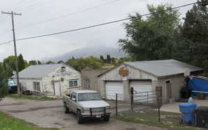 View of front of property featuring a mountain view, a garage, and an outdoor structure