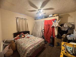 Bedroom featuring carpet, a textured ceiling, and ceiling fan