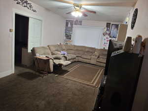 Living room featuring ceiling fan and carpet