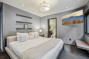 Bedroom with ensuite bath and dark carpet