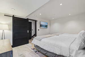 Bedroom featuring a barn door and light wood-type flooring