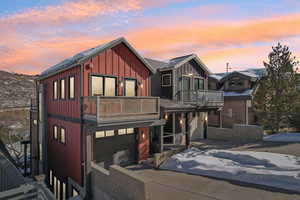 View of front of property featuring a balcony and a garage