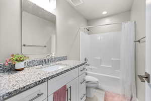 Full bathroom featuring toilet, shower / bath combination with curtain, tile patterned floors, and vanity