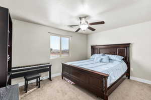 Bedroom with ceiling fan and light carpet