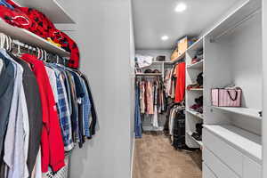 Walk in closet with light carpet