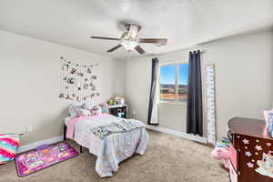 Bedroom featuring ceiling fan, carpet, and a textured ceiling