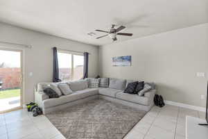 Living room with ceiling fan and light tile patterned flooring