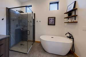 Bathroom featuring vanity, shower with separate bathtub, and concrete floors