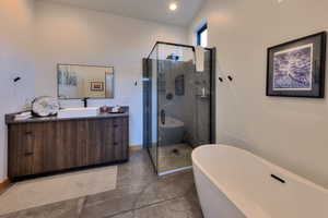 Bathroom featuring vanity, plus walk in shower, and concrete floors