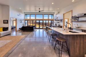 Kitchen featuring a kitchen bar, plenty of natural light, a wall mounted AC, and ceiling fan