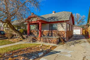 View of front of property with a garage, an outbuilding, and covered porch